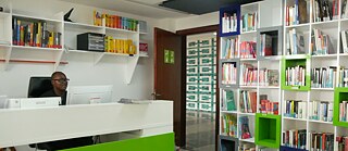 In der Bibliothek sitzen Menschen mit Masken