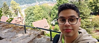 Photo of Alberto Gámez standing in front of a green landscape